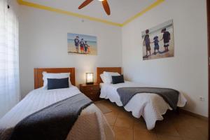 a bedroom with two beds and a ceiling fan at Casa dos Avos in Faro +31 photos