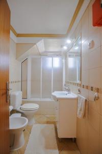 a bathroom with two toilets and a sink and a mirror at Casa dos Avos in Faro