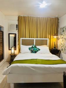 a bedroom with a large white bed with a green blanket at Anton & Isabel Charming Home in Bangued in Bangued
