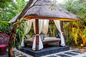 a gazebo with a bed in a garden at 6-BR Private Pool Samudra Villa Tiga Umalas 10min to Canggu Beach in Umalas