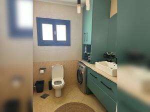 a bathroom with a toilet and a sink and a window at Cozy apartment in Delta Sharm in Sharm El Sheikh +2 photos