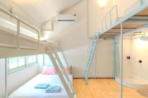 a small bedroom with a bunk bed and a ladder at Green Group Stay Bangkok - Near Khaosan Road in Bangkok