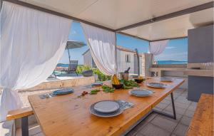 a wooden table with plates on it in a kitchen at Beautiful Home In Zaboric in Zaboric +55 photos
