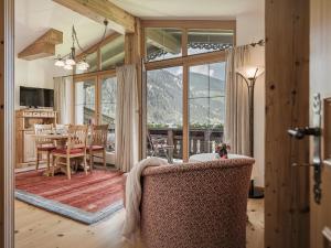 salon ze stołem i krzesłami oraz dużym oknem w obiekcie Apparthotel "Landhaus Veronika" w Mayrhofen