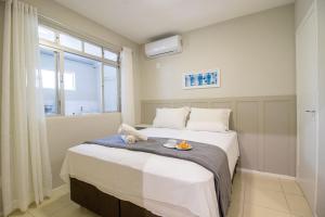 ein Schlafzimmer mit einem Bett und einem Fenster in der Unterkunft JOA22 - 1 Suíte, TV Smart, Aconchegante, Garagem in Balneário Camboriú