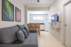 ein Wohnzimmer mit Couch und Küche in der Unterkunft JOA22 - 1 Suíte, TV Smart, Aconchegante, Garagem in Balneário Camboriú