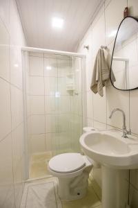 ein weißes Badezimmer mit Toilette und Waschbecken in der Unterkunft JOA22 - 1 Suíte, TV Smart, Aconchegante, Garagem in Balneário Camboriú