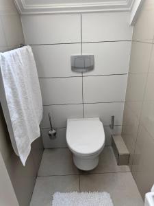 Baño blanco con aseo y toalla en Beautifully furnished loft apartment in central Durbanville, en Durbanville 22 fotos más