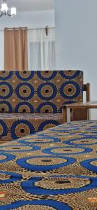 a table and chairs with a blue and gold patterned blanket at SEED-Aeroport Nsimalen Yaounde in Nsimalen