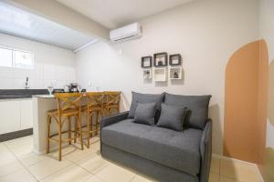 Una sala de estar con un sofá y una cocina. en JOA23 - 1 Dorm, Climatizado, Garagem, TV Smart, en Balneário Camboriú