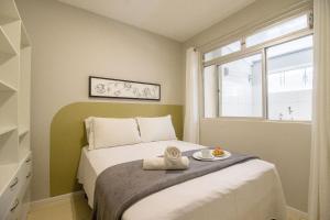 Un dormitorio con una cama con una bandeja de comida encima. en JOA23 - 1 Dorm, Climatizado, Garagem, TV Smart, en Balneário Camboriú