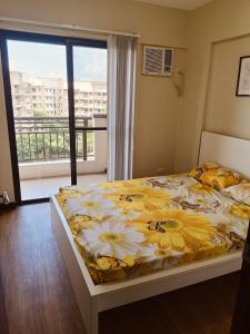 Un dormitorio con una cama con una manta amarilla y blanca. en Asteria Residences Annabel CozyPlace highspeed wifi, en Manila