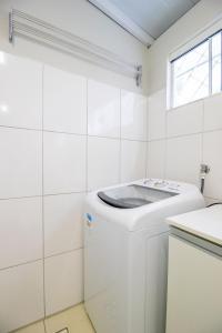 Un lavadero blanco con lavadora y secadora. en JOA23 - 1 Dorm, Climatizado, Garagem, TV Smart, en Balneário Camboriú 10 fotos más