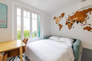 - une chambre avec un lit, un bureau et une carte du monde sur le mur dans l'établissement Cocon comfortable vue mer, Clim et parking, à Sanary-sur-Mer