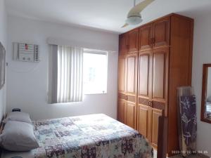 a bedroom with a bed and a wooden cabinet at PRIME Beach e Praia do Forte a Pé e Polo Gourmet com carro no estacionamento. in Cabo Frio