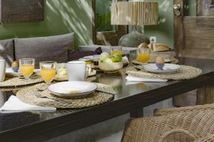 a dining table with plates and glasses of orange juice at Casa com pátio e pequena piscina in Ribeira Fria