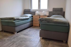 una camera con due letti e un comò con finestra di Ferienhaus 2 - 55471 Reich - EG - OG a Reich