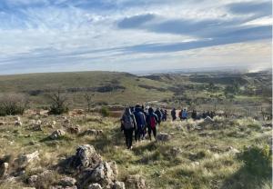 a group of people walking on a grassy hill at Häuschen in Colonia San Miguel