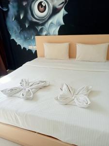 a bed with white sheets with bows on it at GO INN Aonang Beach โกอินน์ หาดอ่าวนาง in Ban Khlong Haeng