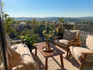 a balcony with chairs and a table with a view at ZEST privè in Kragujevac