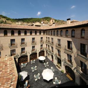 widok z góry na budynek ze stołami i parasolami w obiekcie Hotel Cienbalcones w mieście Daroca