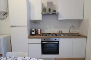 a white kitchen with a stove and a sink at Casa Kaukana - A Pochi Passi dal Mare in Villaggio Azzurro