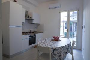 a kitchen with a table and chairs and a kitchen with a refrigerator at Casa Kaukana - A Pochi Passi dal Mare in Villaggio Azzurro