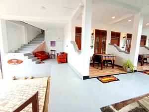 a living room with a staircase and a table at Ramesh Guesthouse in Mirissa