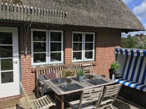 a wooden table and chairs outside of a house at Maltes Hüs in Braderup