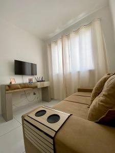 a hotel room with two beds and a television at Ap da Thay - Arretado in Campina Grande