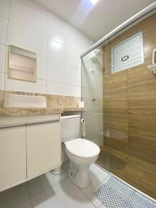 a bathroom with a toilet and a glass shower at Ap da Thay - Arretado in Campina Grande