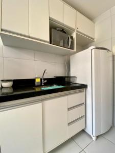a kitchen with white cabinets and a refrigerator at Ap da Thay - Arretado in Campina Grande
