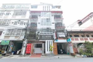 a tall white building with lots of windows at RedDoorz at DBuilders Rooms Ph1 Taguig in Manila