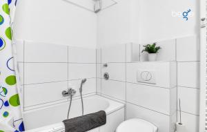a white bathroom with a tub and a toilet at BEGE APARTMENTS Work Comfort in Herten +10 photos