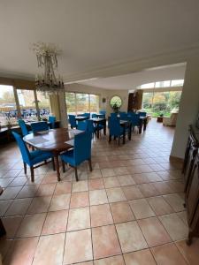 弗尔黎祖Au Charme du Lac Espace bien être et Piscine chauffé proche parc et restaurant du casino的一间带桌子和蓝色椅子的用餐室