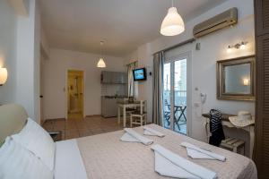 a room with a bed and a kitchen with a table at Diamond Apartments & Suites in Hersonissos