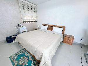 a bedroom with a large white bed in a room at LeTazadit in Zouérat