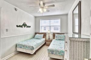 a bedroom with two beds and a ceiling fan at Friendly Native 204 in St Pete Beach +24 photos