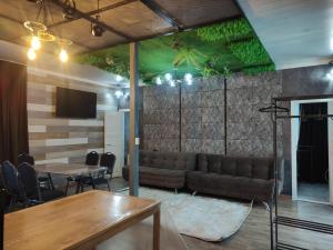 a living room with a couch and a table at Sky loft house in Almaty