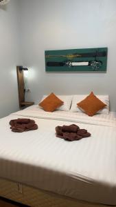 a bed with two brown towels on top of it at Baan Laanta@Lanta in Ko Lanta