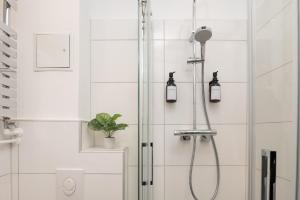 a shower with two lights in a bathroom at Boardinghouse Hohenzollern in Berlin +18 photos