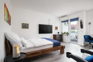 a bedroom with a bed and a tv on the wall at Boardinghouse Hohenzollern in Berlin