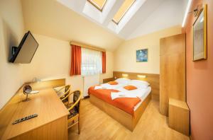a hotel room with a bed and a desk with a computer at Residence Tabor in Prague