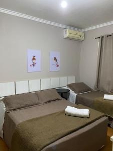 a bedroom with two beds in a room at Pousada dos Pássaros in Gramado