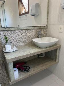 a bathroom with a sink and a mirror at Pousada dos Pássaros in Gramado