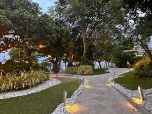 a walkway through a park with trees and plants at Tambuli Seaside Residences Tower C Seaview balcony pool 18mins Aiport in Lapu Lapu City