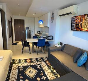 a living room with a couch and a table with chairs at Tambuli Seaside Residences Tower C Seaview balcony pool 18mins Aiport in Lapu Lapu City