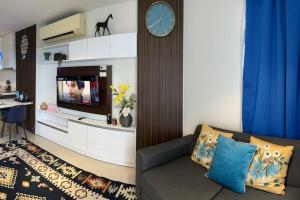 a living room with a couch and a clock on a wall at Tambuli Seaside Residences Tower C Seaview balcony pool 18mins Aiport in Lapu Lapu City