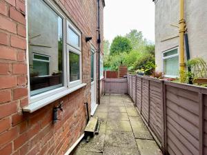 an empty alleyway next to a brick building at Stylish 3-Bedroom Home! in Bedworth