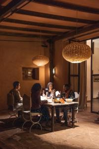 a group of people sitting at a table under lights at Jnane Allia in Douar Soukkane +179 photos